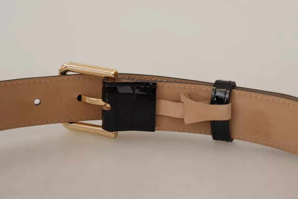 Černý kožený opasek se zlatým kovovým logem a gravírovanou přezkou