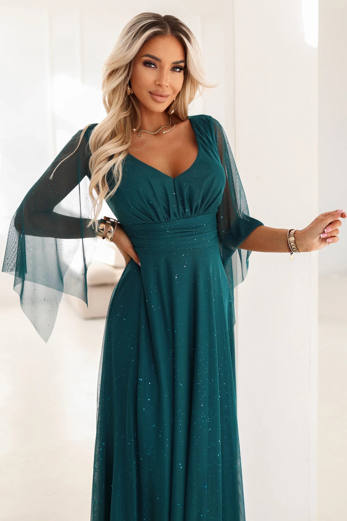A long, shimmering dress with a plunging neckline and sheer sleeves – Emerald Green