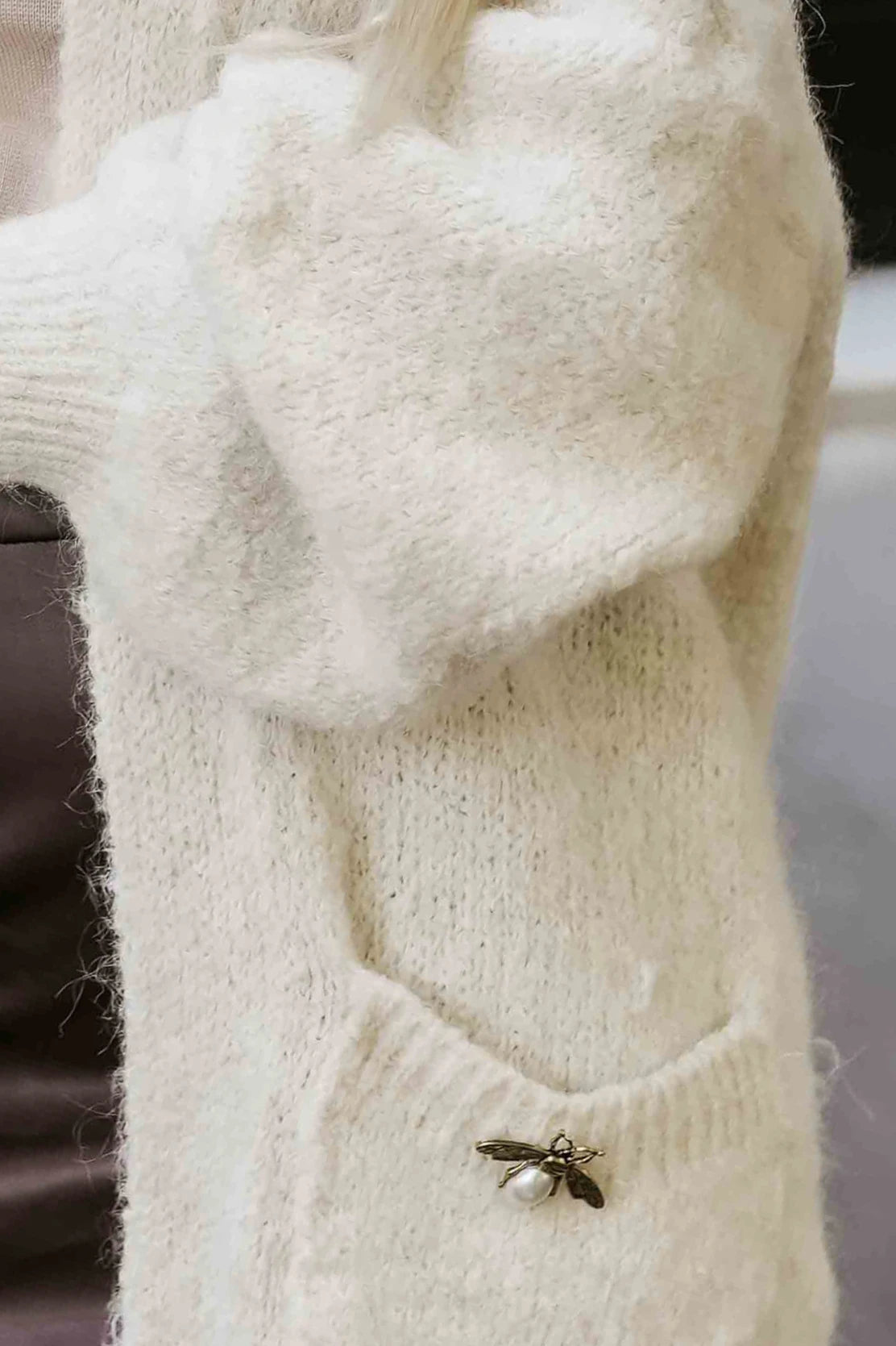 Fashionable oversized cardigan with a decorative brooch and practical pockets – Beige